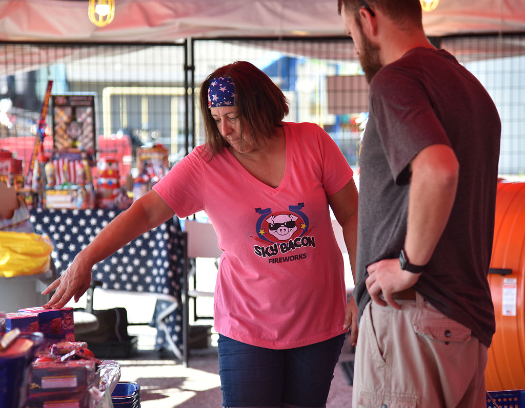 Dyann Butcher shows customer Devan Arends some of the newest fireworks in stock